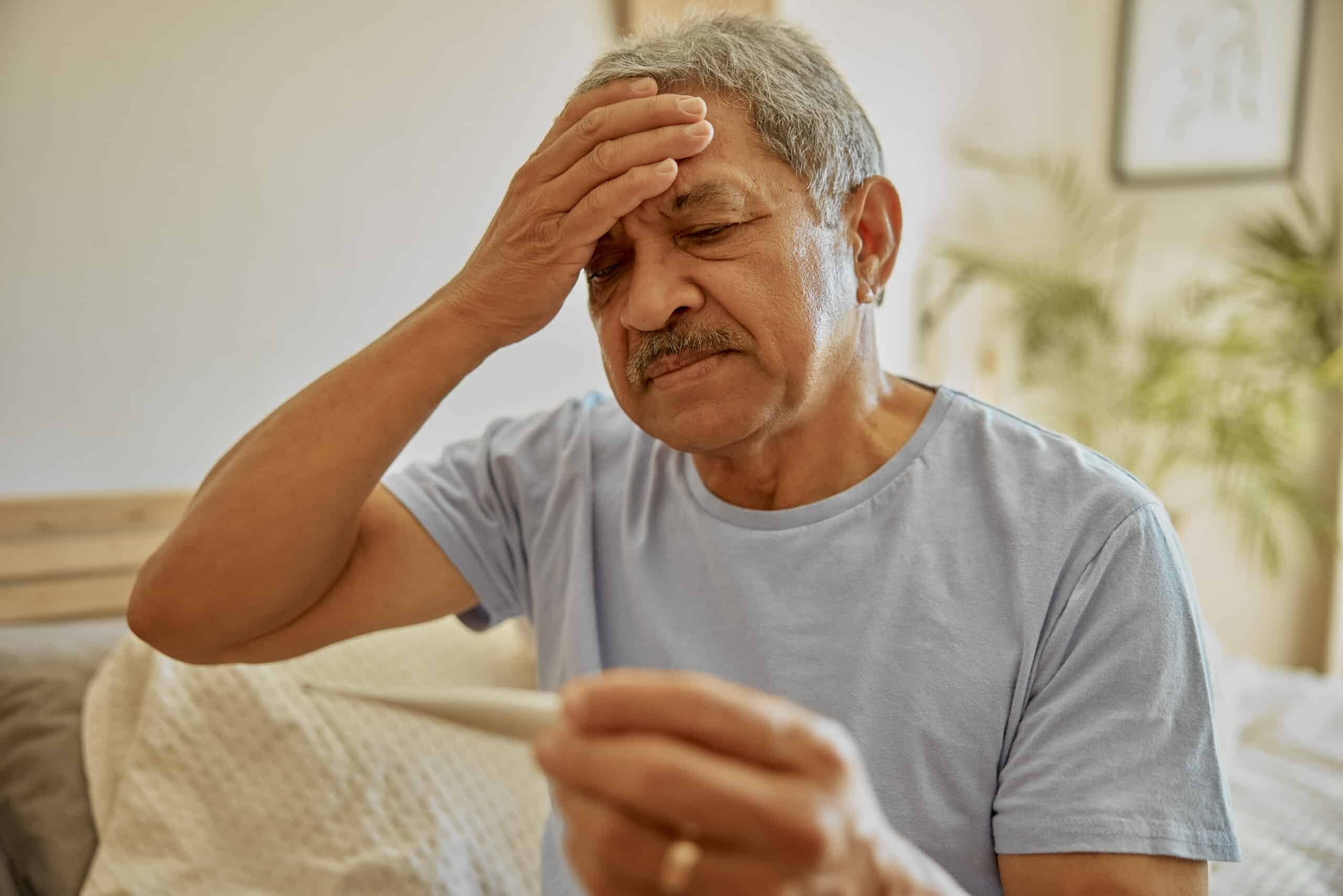 Man with fever holding head