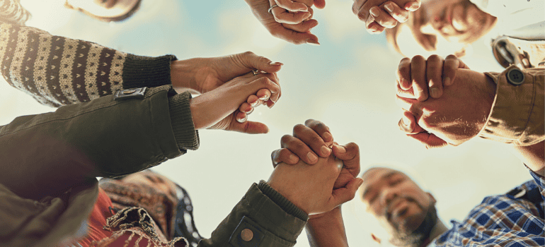 A circle of people hold hands