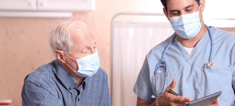 Masked senior and physician speak