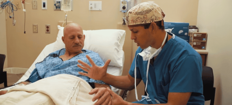 Doctor talking with male patient in a hospital bed