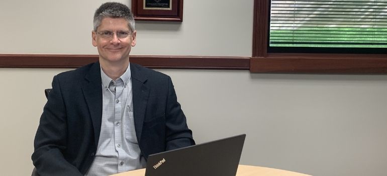 Kettering Health Stroke Medical Director Timothy Schoonover at table with laptop