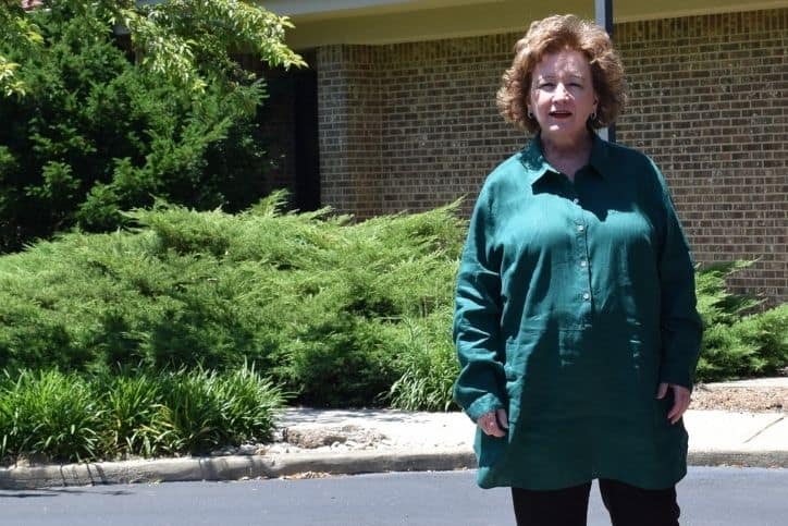 Lisa LePage stands in front of Clearkcreek Chapel bushes