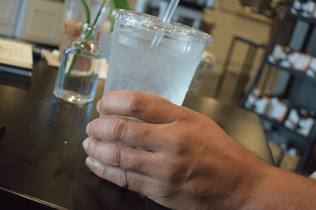 Man holds cup of water at table