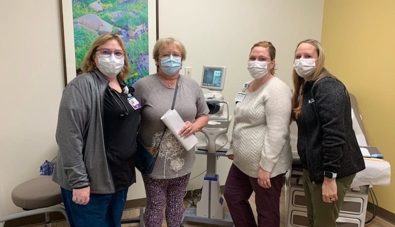 primary care staff around diabetic eye screening machine