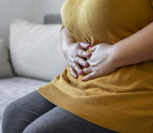 Woman holding her stomach.