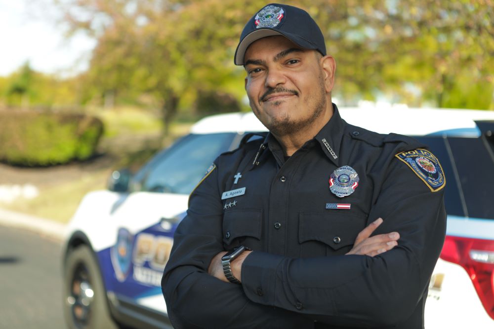 Adalberto Agosto-Burgos standing in front of police car