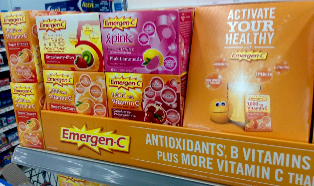 Vitamins and supplements, including Emergen-C, displayed on a drugstore shelf.