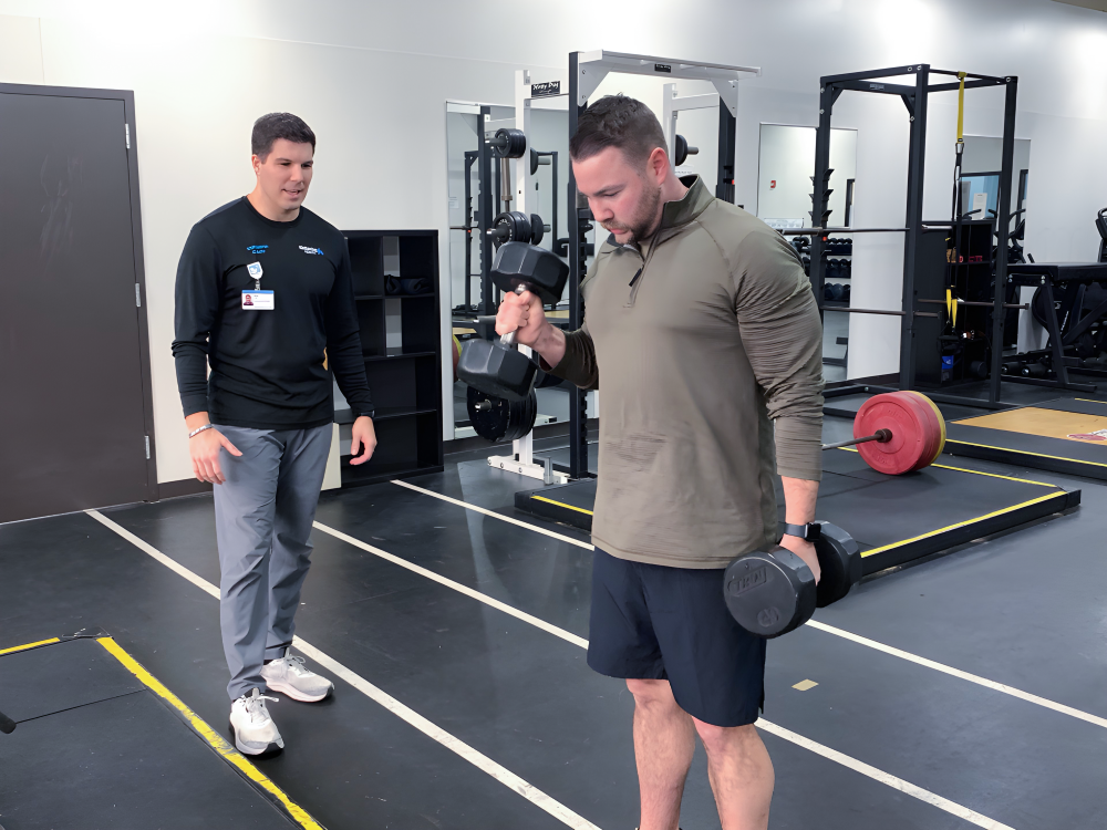 Rex Carpenter coaching a man lifting weights to help him reach his fitness goals