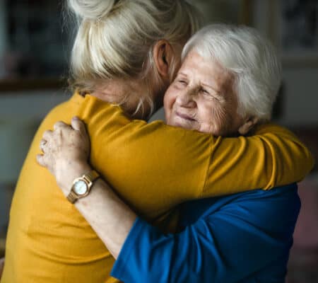 Woman hugging her elderly mother