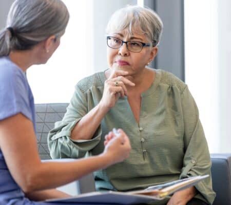 elderly woman talking to doctor waiting room