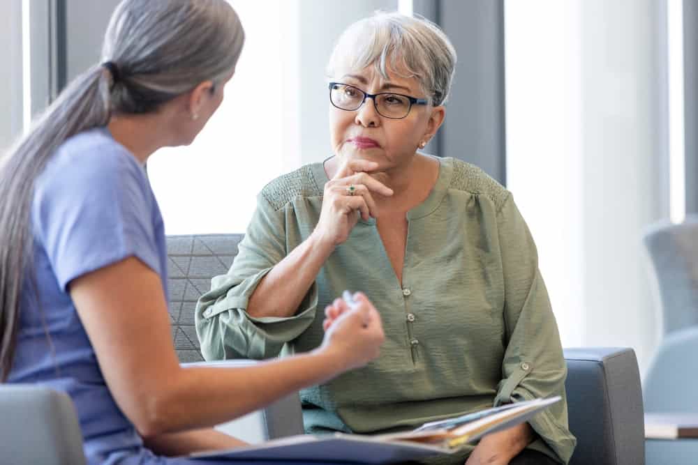 elderly woman talking to doctor waiting room