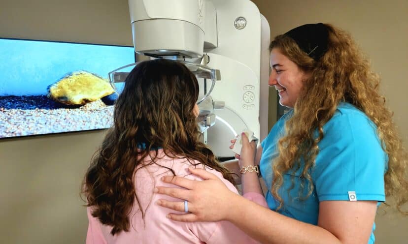 Woman doing patient-controlled compression during a mammogram
