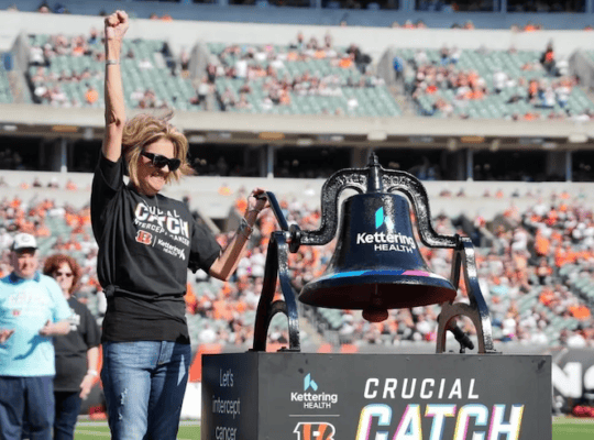 Female cancer survivor celebrating at the crucial catch game