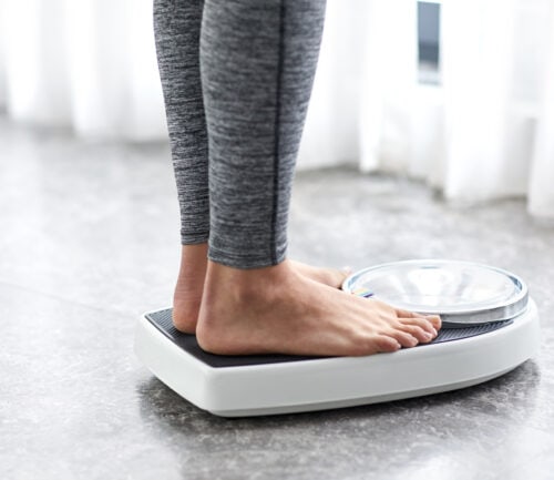Woman standing on scale, showing just her feet