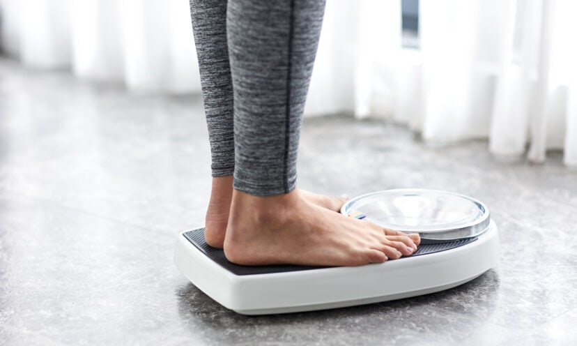 Woman standing on scale, showing just her feet