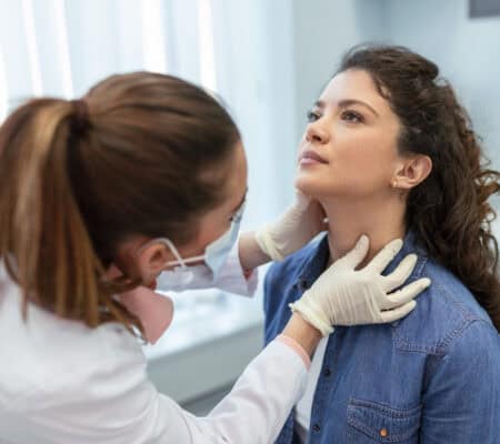 Woman getting her thyroid checked by a doctor