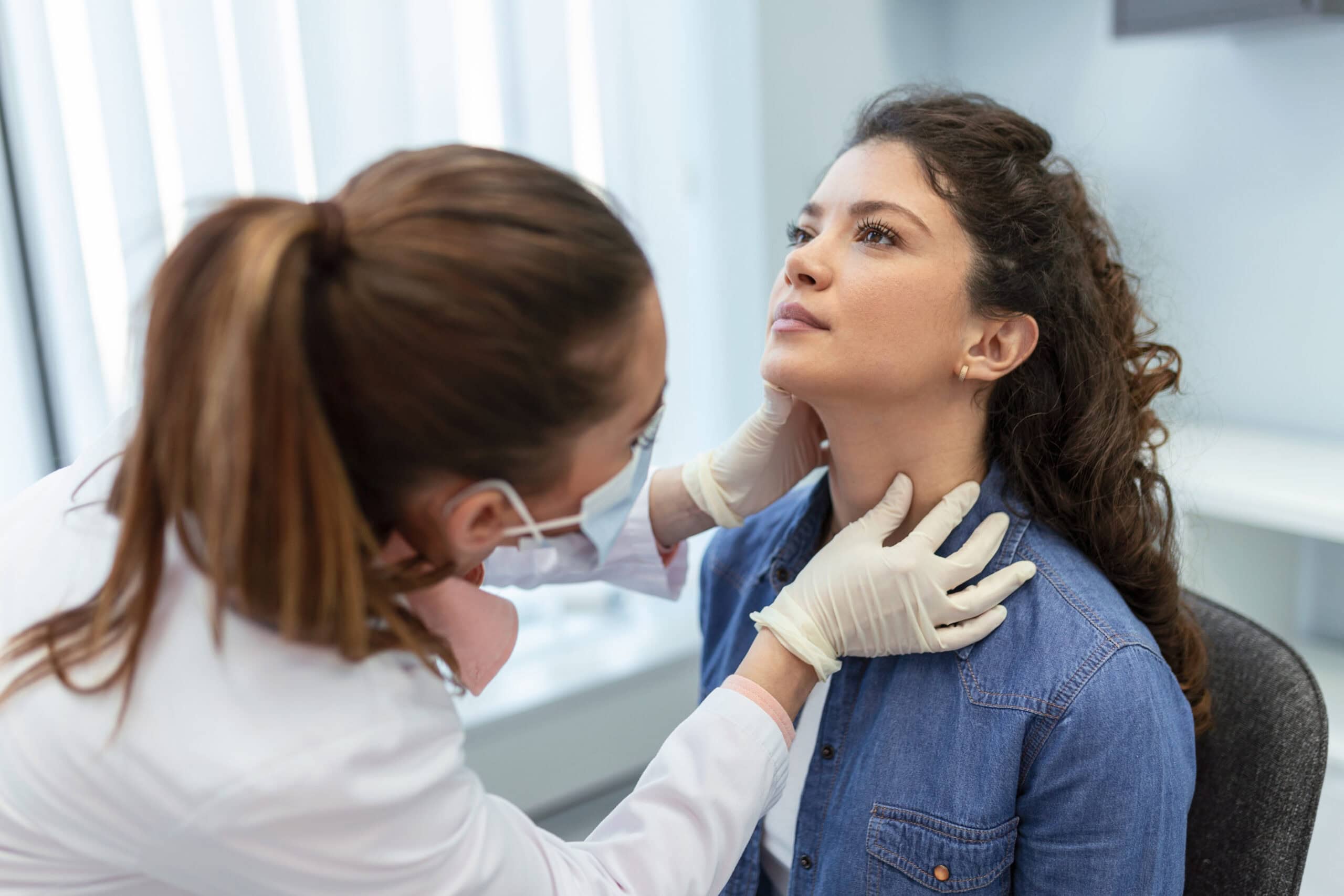 Woman getting her thyroid checked by a doctor