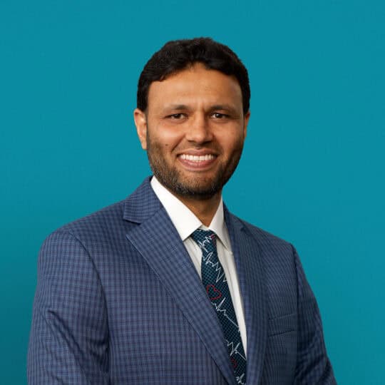 Professional headshot of Dr. Abdur Rehman in blue suit against teal background
