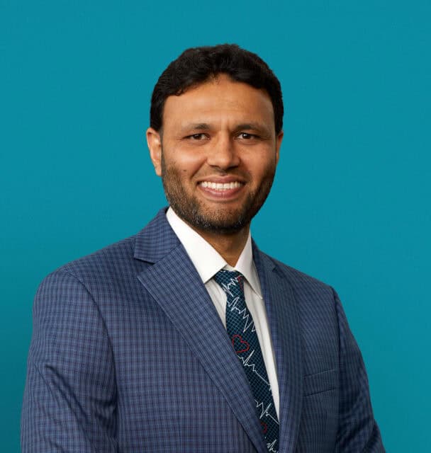 Professional headshot of Dr. Abdur Rehman in blue suit against teal background