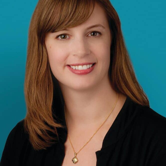 Professional headshot of Dr. Aimee G. Russell smiling against turquoise background