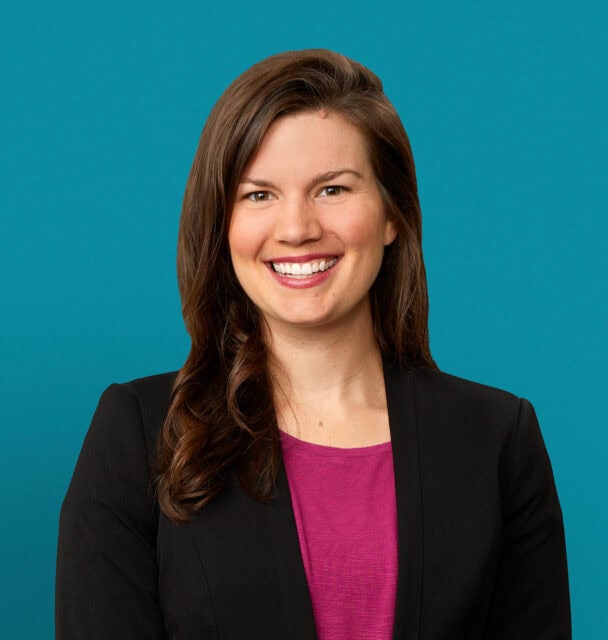 Professional headshot of Dr. Allyson Halderman in black blazer against teal background