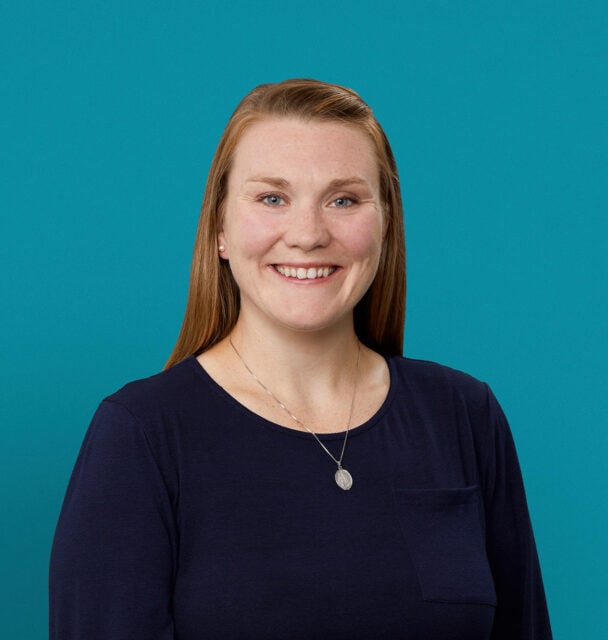 Professional headshot of Amy Knotts, APRN-CNP, smiling in navy top against teal background