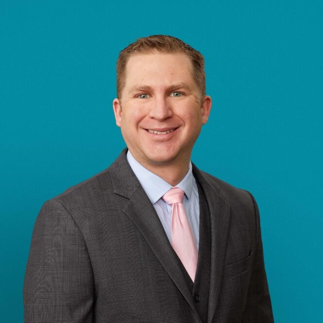 Professional headshot of Andrew D. Galusha, MD in gray suit with pink tie