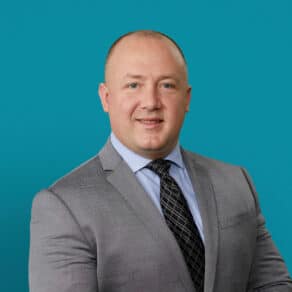 Professional headshot of Anthony Blanchard, DPM in gray suit against teal background