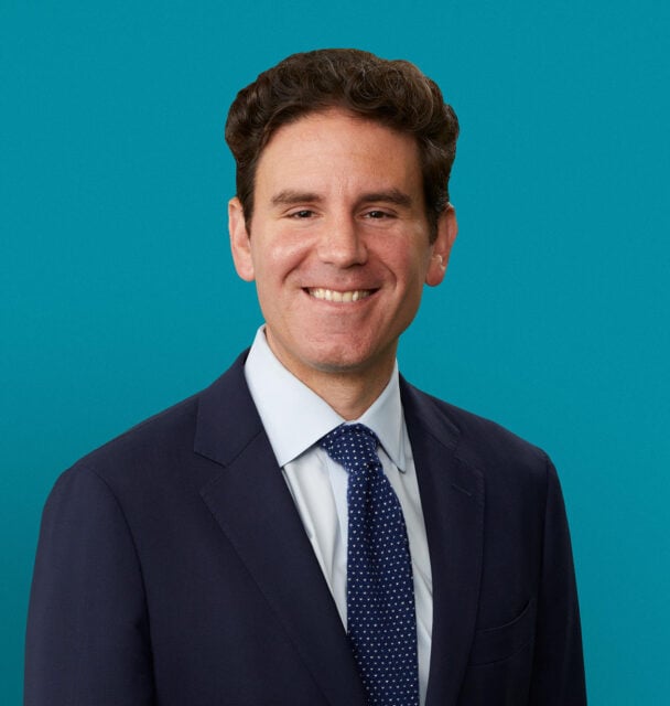 Professional headshot of Dr. Anthony J. Paravati in navy suit against teal background