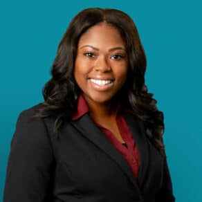 Professional headshot of Asia L. Richardson, APRN-CNP in dark suit against teal background