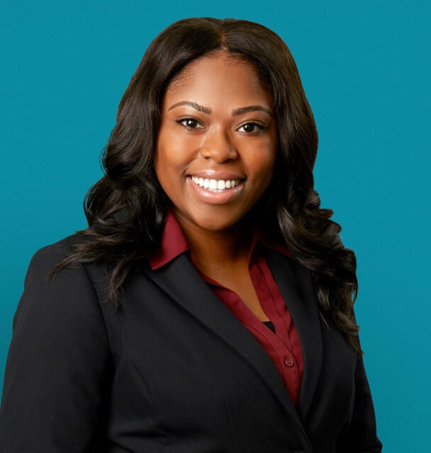 Professional headshot of Asia L. Richardson, APRN-CNP in dark suit against teal background