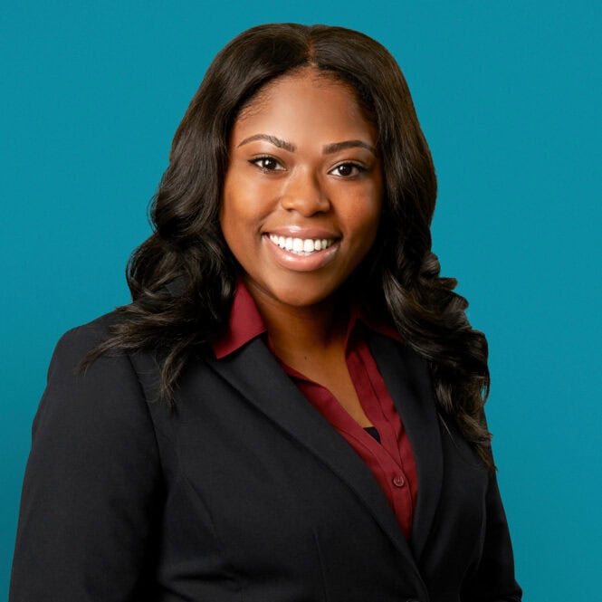 Professional headshot of Asia L. Richardson, APRN-CNP in dark suit against teal background