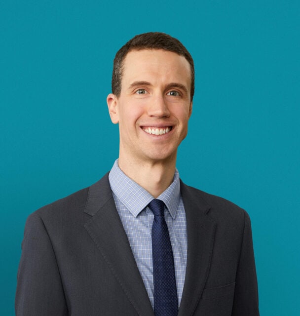 Professional headshot of Benjamin S. Cooley, MD in dark suit against teal background
