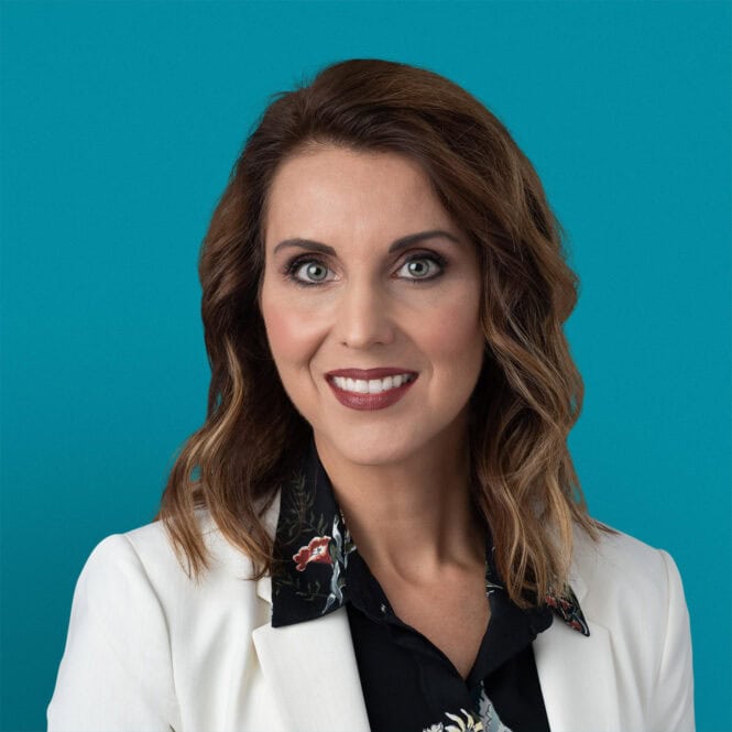 Professional headshot of Carmen C. Gruia, APRN-CNP in white blazer with floral top