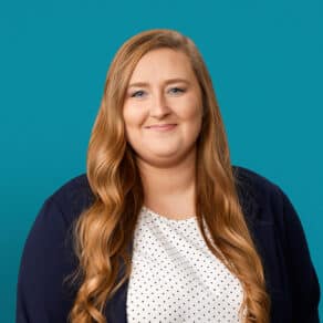 Professional headshot of Caroline Symons, PA-C against teal background wearing navy blazer