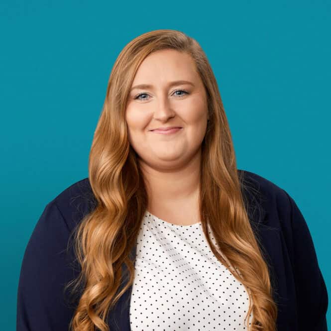 Professional headshot of Caroline Symons, PA-C against teal background wearing navy blazer