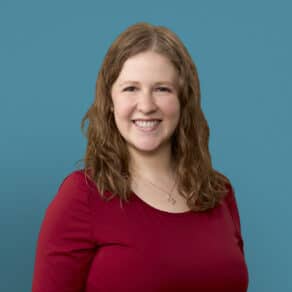 Professional headshot of Dr. Chantal Berning in red top against blue background