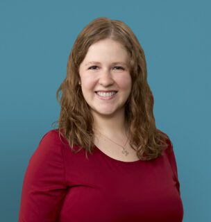 Professional headshot of Dr. Chantal Berning in red top against blue background