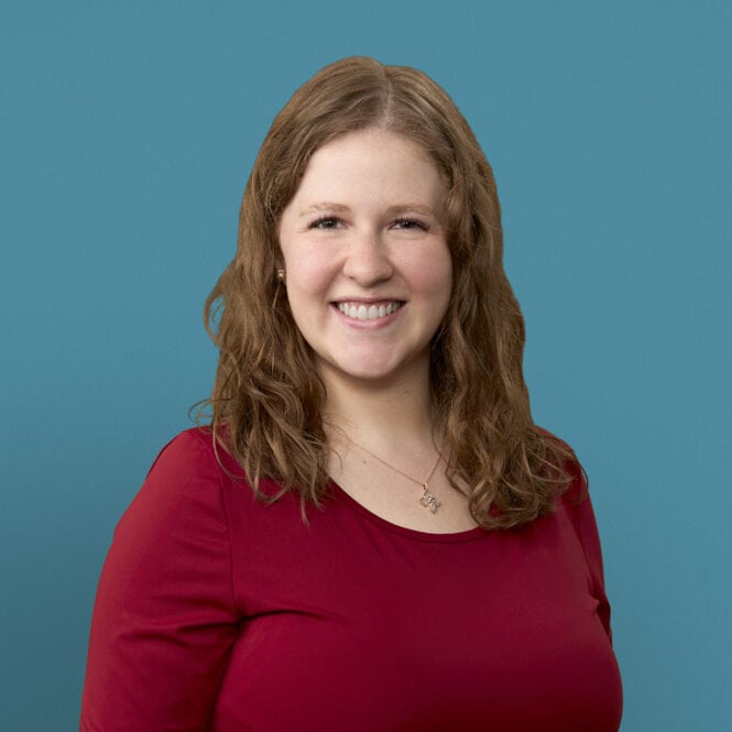 Professional headshot of Dr. Chantal Berning in red top against blue background