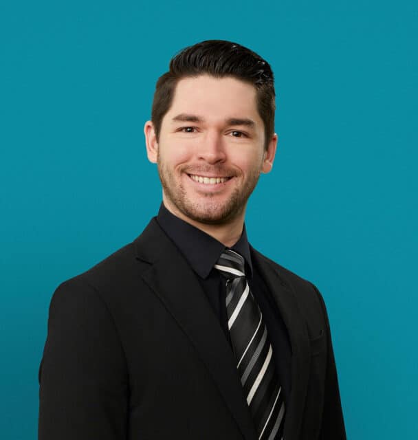 Professional headshot of Charles Swafford, APRN-CNP in dark suit against teal background