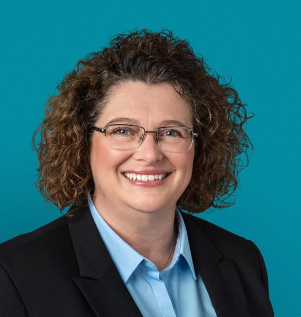 Professional headshot of Christine A. Leak, APRN-CNP, smiling in business attire with glasses