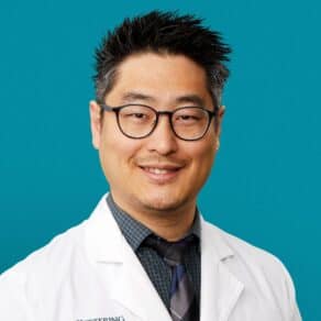 Professional headshot of Dr. Christopher H. Lee in white coat smiling at camera