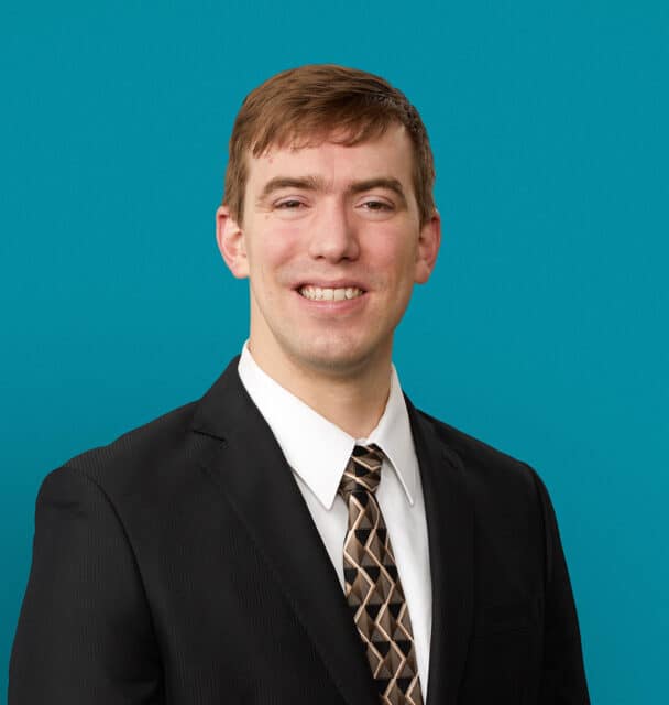 Professional headshot of Christopher M. Lawrence, APRN-CNP in dark suit against teal background