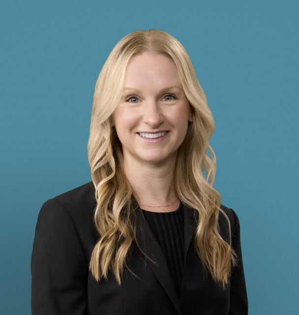 Professional headshot of Claire Healy, DO, smiling woman with blonde hair in black blazer