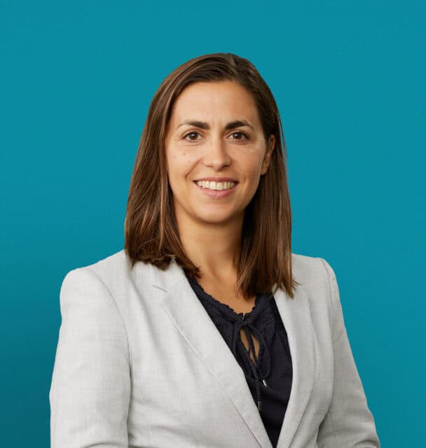 Professional headshot of Daniela Rosu, MD in light gray blazer against teal background