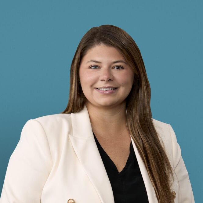Professional headshot of Danielle Thomas, APRN-CNP in white blazer against blue background