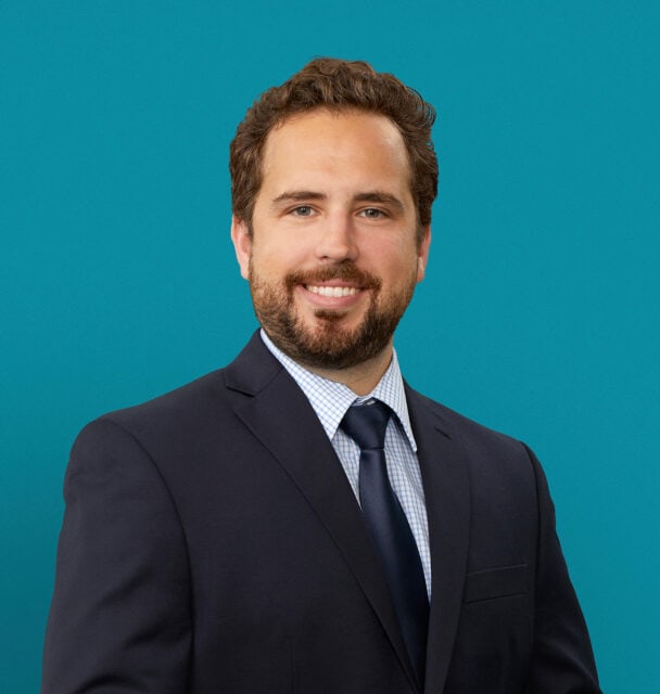 Professional headshot of David de la Peña, DO in dark suit against teal background