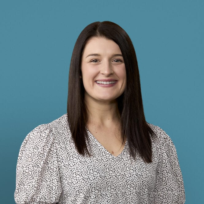 Professional headshot of Delani Deckard, APRN-CNP, smiling in polka dot blouse