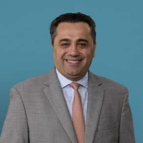 Professional headshot of Dimitrios Topalidis, MD in gray suit and orange tie