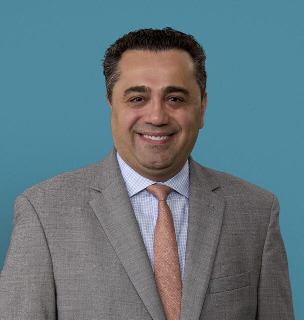 Professional headshot of Dimitrios Topalidis, MD in gray suit and orange tie